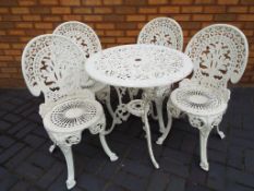 A cast aluminium garden table 69 cm (diam) with four chairs