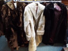 Three fur coats, one in black approximate length 115 cm,