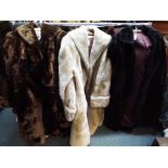 Three fur coats, one in black approximate length 115 cm,