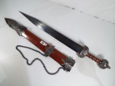 A replica late Empire Gladius with engraved blade and wood effect scabbard,