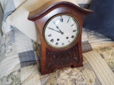 A oak cased alarm clock, Roman numerals on a white dial, clockwork mechanism, 17.