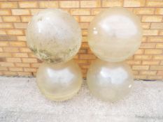 Four large vintage perspex globe shaped light shades.