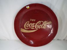 A large round tray advertising Coca-Cola.