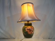 Moorcroft Pottery - a table lamp decorated with pink coral hibiscus on a green ground with shade,