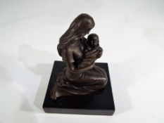 A bronze figure of a mother and child, approximate height 12 cm.