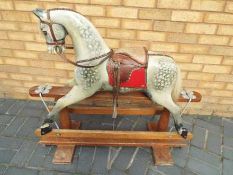 Kensington Rocking Horse Company - a carved wooden rocking horse with dapple grey painted features