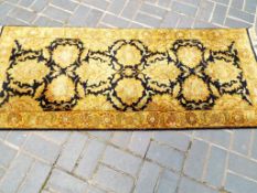 A rectangular Indian wool rug gold and navy floral,