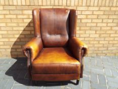 A good quality leather wing back armchair