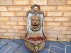 A good quality Victorian cast iron wall mounted water feature bearing a lion's head approximate