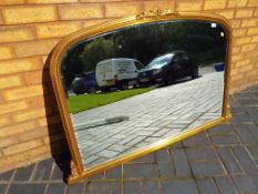A large bevel edged mantle mirror in an ornate gold gilded frame,