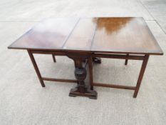 An oak drop-leaf table 76 cm x 31 cm x 90 cm extending to 148 cm