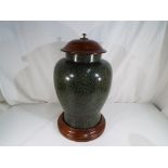 A large lidded urn with solid wooden pli