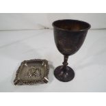 A George V hallmarked silver goblet Birmingham assay 1932 and a silver plated ashtray with relief