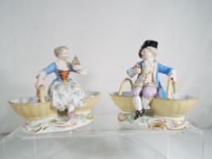 Two 19th century figurines gentleman and a lady in period costume with large basket in each hand,