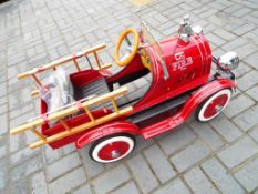 Pedal Car - A vintage classic toy American style fire truck pedal car with spare steering wheel,