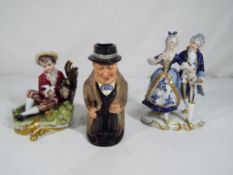 A Royal Doulton Toby jug depicting Winston Churchill and two further European ceramic figurines to