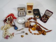 A good mixed lot of costume jewellery to include a hallmarked silver brooch set with Baltic amber