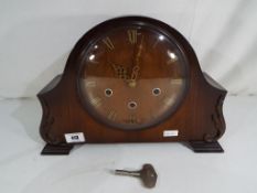 An oak cased Smiths mantel clock, Roman numerals to the dial with pendulum and key.
