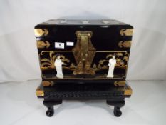 A good quality lacquered Asian luxury jewellery box with lock with relief decoration set with