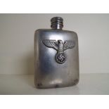 A white metal cigarette flask with screw top and bearing an applied plaque with eagle,