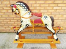 An antique Collinson rocking horse with mottled body,
