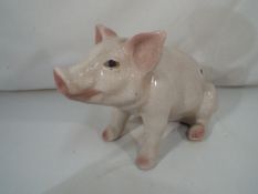 A ceramic model of a seated pig,