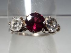 A lady's garnet and diamond three stone presumed 18ct white gold ring, approx diamond weight 0.