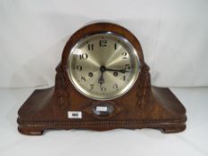 A highly carved oak cased mantel clock with pendulum and key,