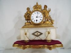 A late 19th century French ormulu mantel clock over a shaped white marble base,