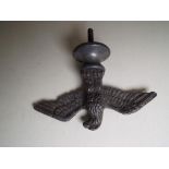 A white metal figure depicting an Eagle with Spread Wings on a base with screw thread below,