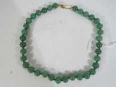 A green hardstone knotted beaded necklace (possible jade) 35 beads in total,