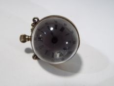 A miniature Bullseye glass pocket watch with open style movement.