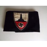 World War Two (WW2) - a German SS black armband bearing German Veterans cloth badge with lighthouse
