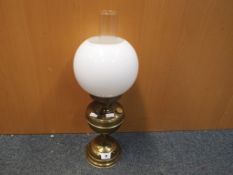 A good quality brass oil lamp with white spherical glass shade, approximate height 50 cm.