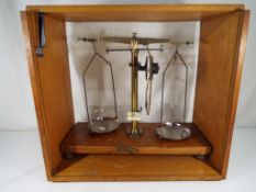 A set of brass balance scales by Philip Harris & Co of Birmingham within a wooden box