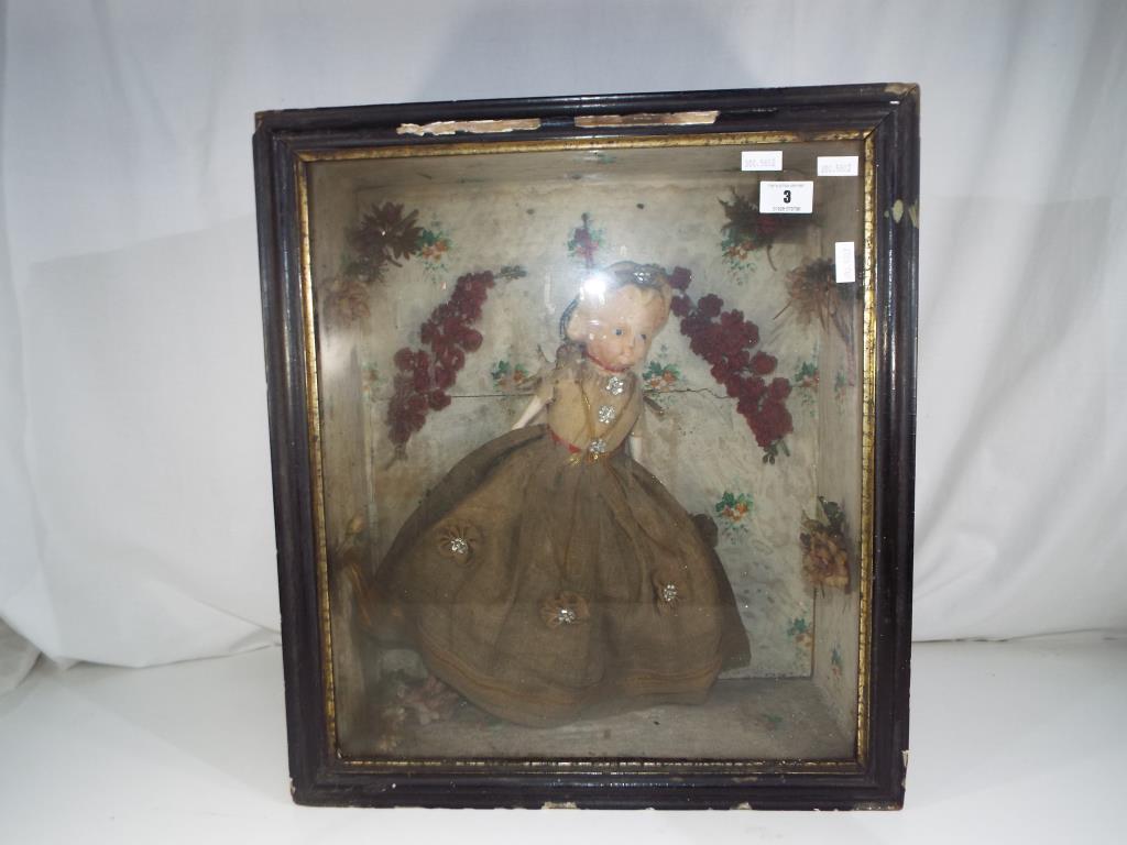 An antique wax doll in a wooden display case, approximately 38 cm doll size,