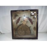 An antique wax doll in a wooden display case, approximately 38 cm doll size,
