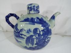 A large Asian teapot depicting landscape scenes, with four panels, maker's mark to the base,