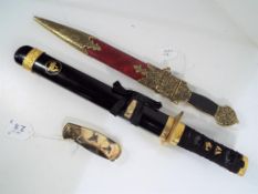 Two replica daggers of which one Chinese and one Japanese with a folding knife decorated with a