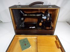 A vintage Singer sewing machine in carry case.