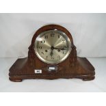 A carved oak cased mantel clock with pendulum and key,