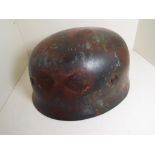 World War Two (WW2) - a steel helmet with leather liner and chin strap, marking within unclear,