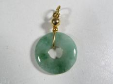 A jade and unmarked 9 carat gold pendant
