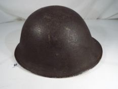 A military helmet with liner and canvas chin strap, unmarked.