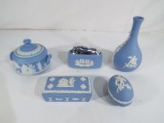 Wedgwood - five pieces of Blue Jasperware comprising table lighter, bud vase,
