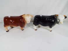 Two good quality Melba Ware ceramic models of bulls, one in black approximately 16 cm (h),