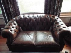 A brown leather button back Chesterfield two seater sofa,