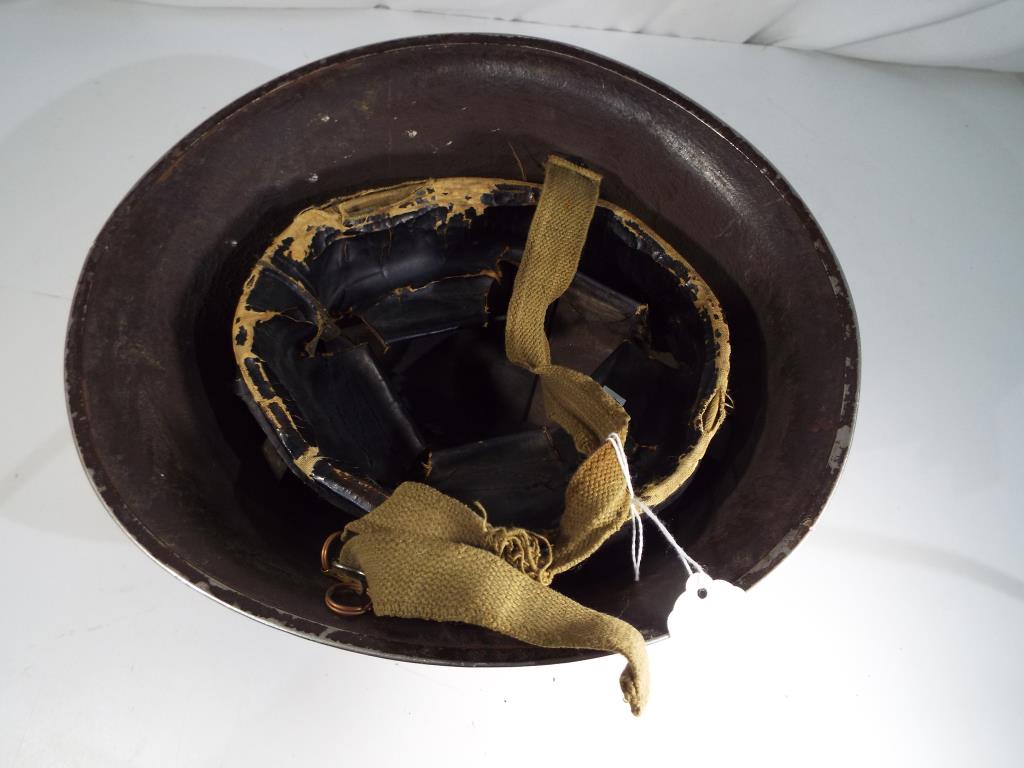 A military helmet with liner and canvas chin strap, unmarked. - Image 2 of 2