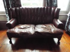 A brown leather high back two seater sofa,