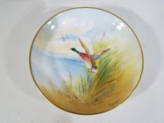 Minton - a pin dish by Minton decorated with a Mallard in flight, signed P Gosling,